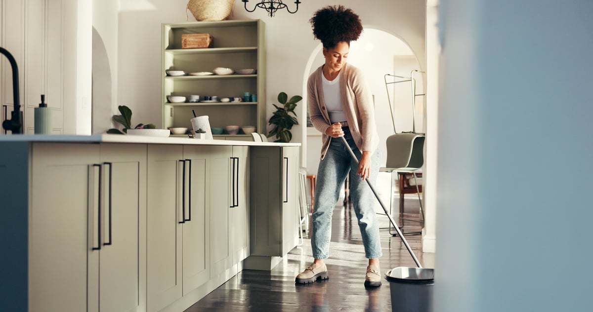 Hygiene, woman and cleaning with mop on floor for housework, housekeeping or maintenance service. Happy African cleaner, home and chores in kitchen with tools for sanitation, bacteria safety or shine